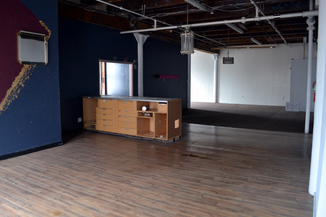 Open-concept commercial real estate space in Kansas City’s West Bottoms featuring hardwood floors, exposed ceilings, and natural light — ideal for a studio, retail shop, or creative office.
