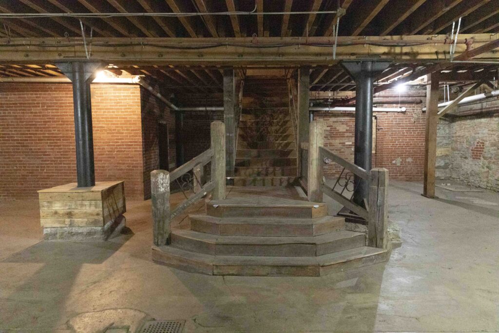 Commercial Real Estate in Kansas City's West Bottoms. Historic basement commercial space in Kansas City's West Bottoms featuring exposed brick walls, concrete flooring, steel support columns, and original industrial architecture.